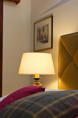 a lamp sitting next to a bed in a bedroom at Burgunderhof - Steiermark in Sankt Anna am Aigen
