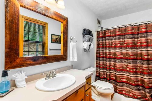 een badkamer met een wastafel, een toilet en een spiegel bij Gunny's Cabin in Stewart Mill