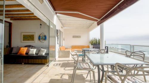 a patio with a table and chairs and a couch at Condominio Maradentro - Casas de playa en exclusivo balneareo de chepeconde in Los Leones