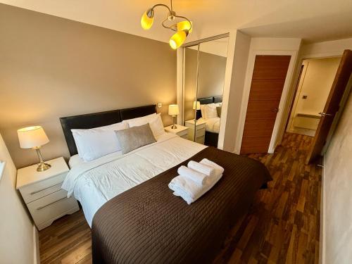 a bedroom with a large bed with two towels on it at Bloom Apartments - City Centre - Gated Parking in Manchester