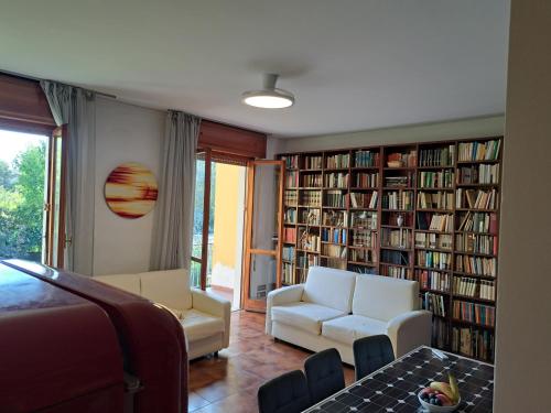 a living room with two white chairs and bookshelves at Book Paradise in Cremona
