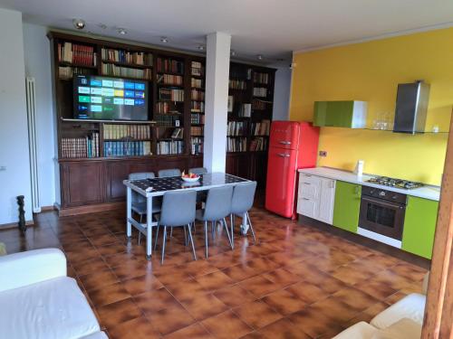 a kitchen with a table and chairs and a red refrigerator at Book Paradise in Cremona