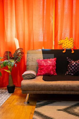 a living room with a couch in front of an orange curtain at Alejandra By Silastur in Gijón