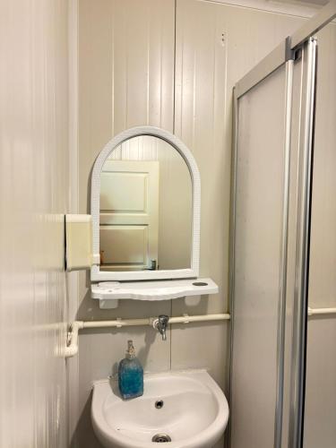 a white bathroom with a sink and a mirror at ŞAH apart in Kemer