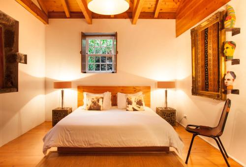 a bedroom with a bed and a window and a chair at Pocinhobay in Madalena
