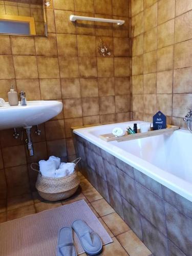 a bathroom with a tub and a sink and a bath tub at Haus Stille Oase in Bruck an der Großglocknerstraße