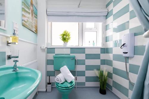 a bathroom with a green toilet and a sink at Coastal Village Hideaway in Scalby