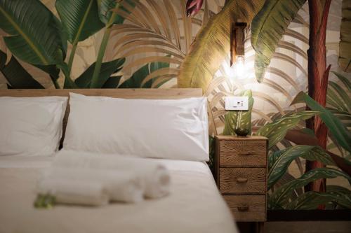a bedroom with a bed with white sheets and a plant at Suite 45 - Relax & Comfort in Bari