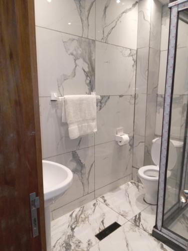 a bathroom with a sink and a toilet at Residence Julie in Douala