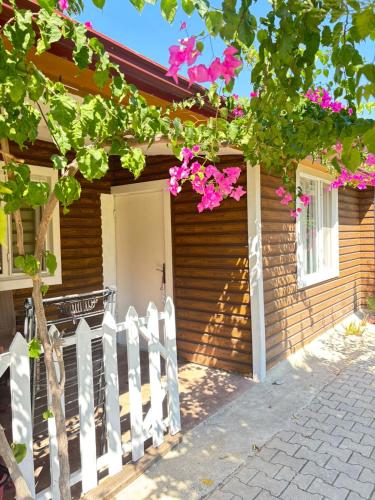 a house with a white fence and pink flowers at ŞAH apart in Kemer