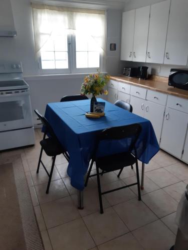 een keuken met een tafel met een blauwe tafeldoek erop bij Markland Cottage Winery in Whitbourne