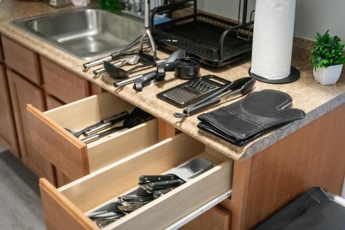 a kitchen counter with a sink and a drawer with utensils at King Bed 2 TVs Fast Wifi Pet Friendly! in Cleveland