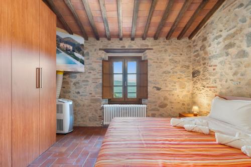 a bedroom with a bed in a room with stone walls at Agriturismo La Marginella in Pescia