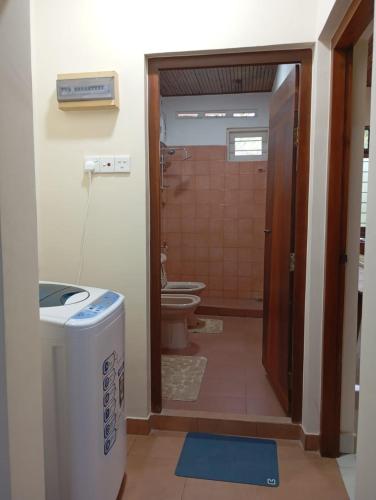 a bathroom with a shower and a toilet and a door at Amara Garden Villa in Kadawata