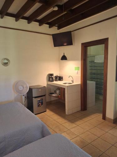a bedroom with a bed and a bathroom with a sink at Playa Negra Guesthouse in Cahuita