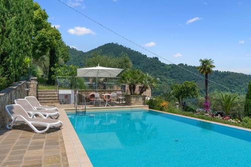 a swimming pool with two chairs and an umbrella at Agriturismo La Marginella in Pescia