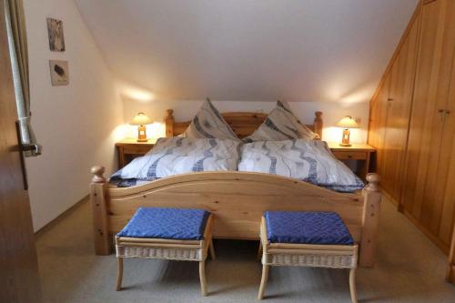 a bedroom with a wooden bed with two stools at Ferienwohnung Nordenau in Schmallenberg