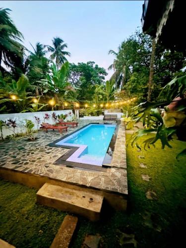 a swimming pool in the middle of a yard at Villa 1908 in Dodanduwa