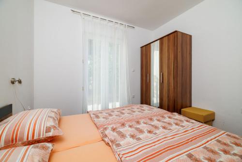 ein Schlafzimmer mit einem Bett und einem Holzschrank in der Unterkunft Apartment Villa Sara in Dramalj