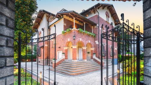 an image of a house with an iron gate at Villibera - Design villa with SPA, Cinema, Gym and Game Room in Cesano Maderno