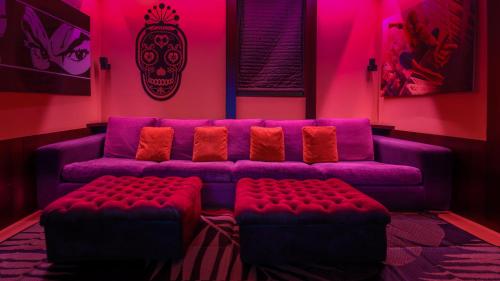 a living room with a purple couch and a skull picture at Villibera - Design villa with SPA, Cinema, Gym and Game Room in Cesano Maderno