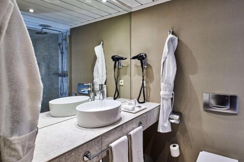 a bathroom with two sinks and a large mirror at NH Collection Prague in Prague