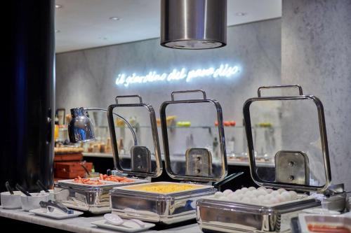 a buffet line with food in trays on a counter at NH Collection Prague in Prague