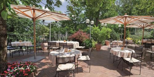 a patio with tables and chairs with umbrellas at NH Collection Prague in Prague