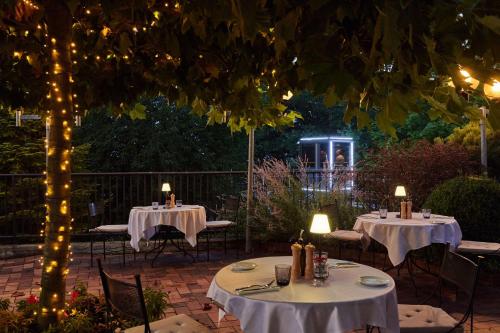 two tables and chairs with lights on a patio at NH Collection Prague in Prague