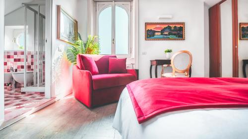 a bedroom with a red bed and a chair at Villibera - Design villa with SPA, Cinema, Gym and Game Room in Cesano Maderno