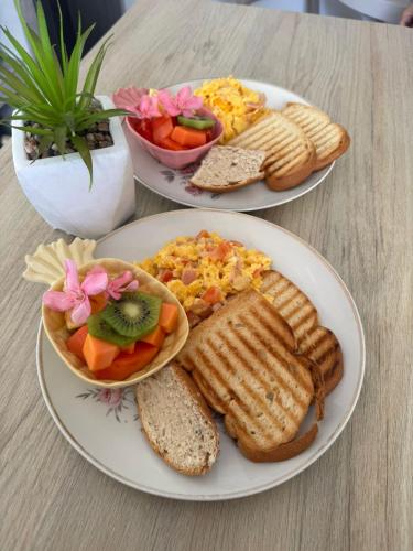two plates of breakfast food on a table at Colorful Garden House in Providencia