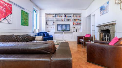 a living room with a leather couch and a fireplace at Villibera - Design villa with SPA, Cinema, Gym and Game Room in Cesano Maderno