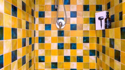a tiled bathroom with a shower with a shower head at Villibera - Design villa with SPA, Cinema, Gym and Game Room in Cesano Maderno