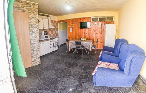 a living room with a blue couch and a kitchen at Departamento en Caleta Olivia cerca del mar in Caleta Olivia