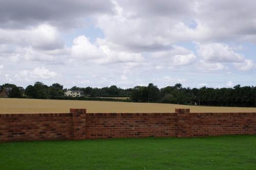 a brick wall with a field in the background at Luxury Bungalow Countryside view in Aughton