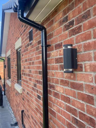 a black pipe attached to a brick wall at Luxury Bungalow Countryside view in Aughton