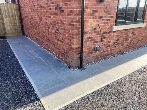 a brick wall and a sidewalk next to a building at Luxury Bungalow Countryside view in Aughton