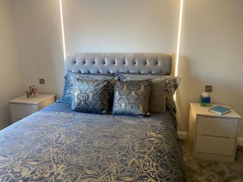 a bedroom with a bed with blue sheets and pillows at Luxury Bungalow Countryside view in Aughton