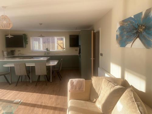 a living room and kitchen with a couch and a table at Luxury Bungalow Countryside view in Aughton