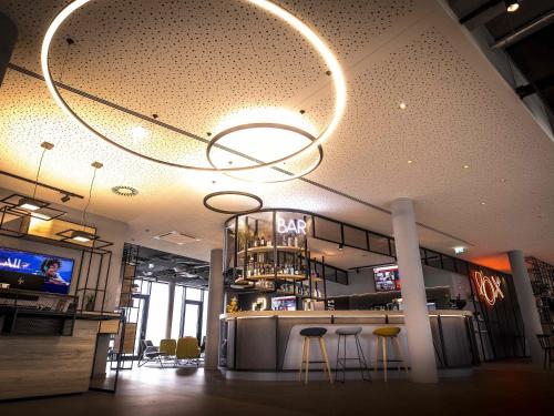 a restaurant with a bar and stools in a room at ibis Wels in Wels