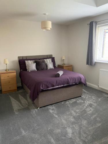 a bedroom with a bed with a purple comforter at Luxury Bungalow Countryside view in Aughton