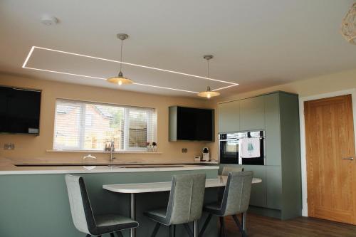 a kitchen with a table and chairs and a counter at Luxury Bungalow Countryside view in Aughton