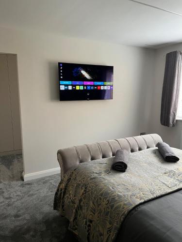 a bedroom with a bed and a tv on the wall at Luxury Bungalow Countryside view in Aughton