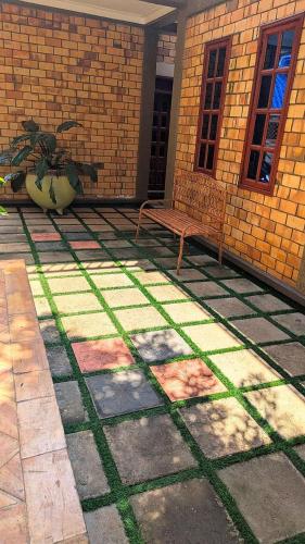 a patio with a bench and a brick wall at Cozy Safari in Entebbe