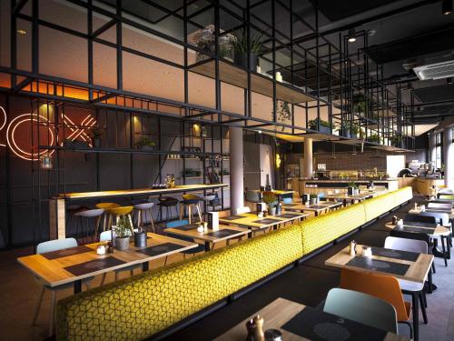 a restaurant with tables and chairs and a yellow at ibis Wels in Wels