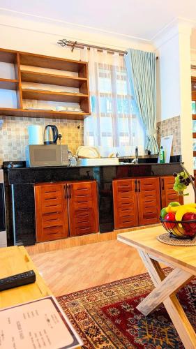 a kitchen with wooden cabinets and a counter top at Cozy Safari in Entebbe