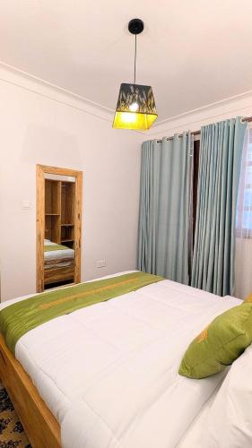 a bedroom with a large bed and a chandelier at Cozy Safari in Entebbe