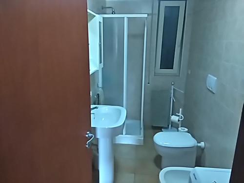 a bathroom with a white sink and a toilet at Apartment C in Ginosa Marina