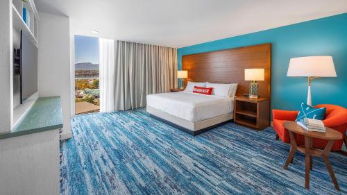 a hotel room with a bed and a desk and a chair at Compass by Margaritaville Hotel Pigeon Forge in Pigeon Forge