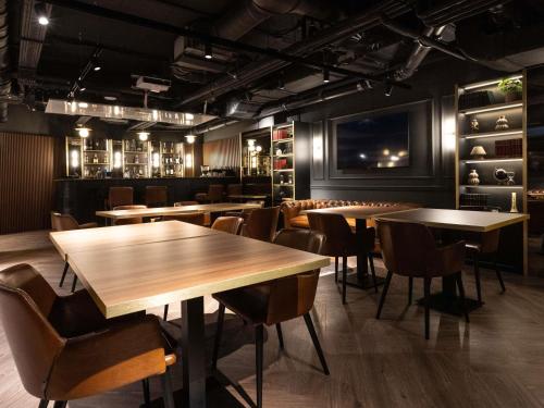 a restaurant with tables and chairs and a bar at Mercure Timisoara in Timişoara